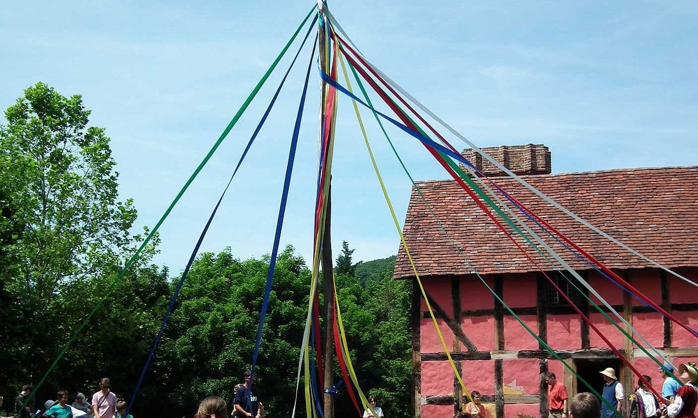 Group of people dancing at the may pole.